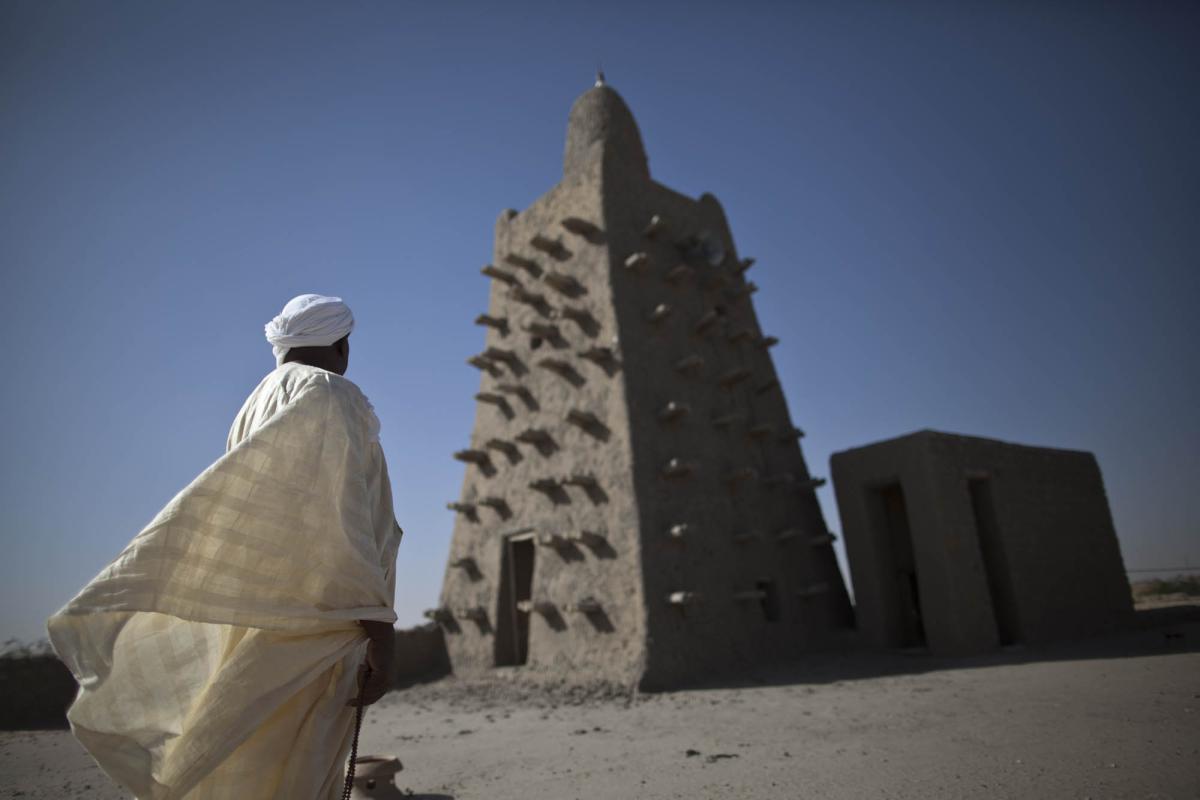 Photo: A devout man in prayer in front of the Djingareyber Mosque minaret in Timbuktu, a powerful symbol of the resilience of the local community. Through heritage preservation measures, the TFV programme helped restore sites of profound cultural and spiritual significance to Muslim populations, and which were destroyed in attacks taking place between 30 June and 11 July in 2012. Credit: MINUSMA/Marco Dormino.